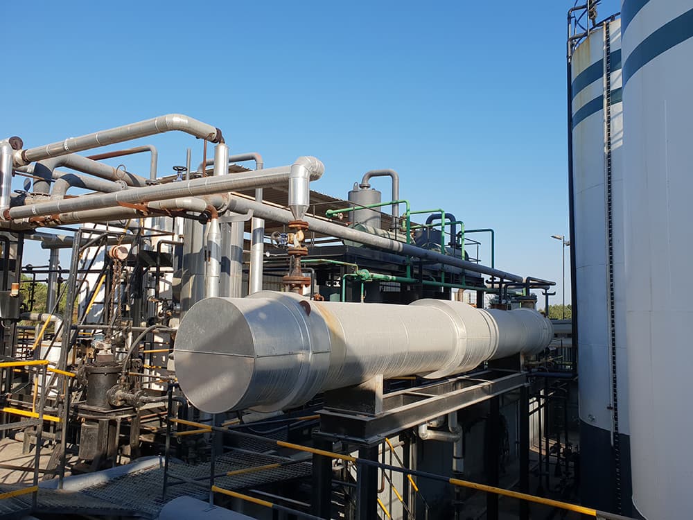 Instalaciones industriales con tuberías y tanques al aire libre bajo cielo despejado