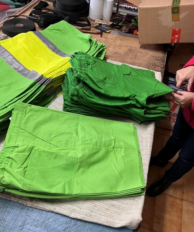 Persona recortando ropa de trabajo para crear neceseres.